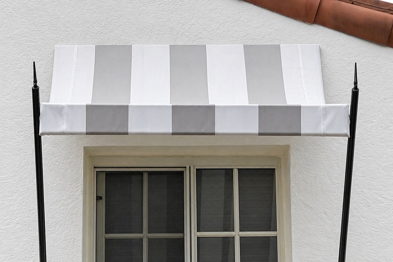 White-and-gray striped window awning with spear supports